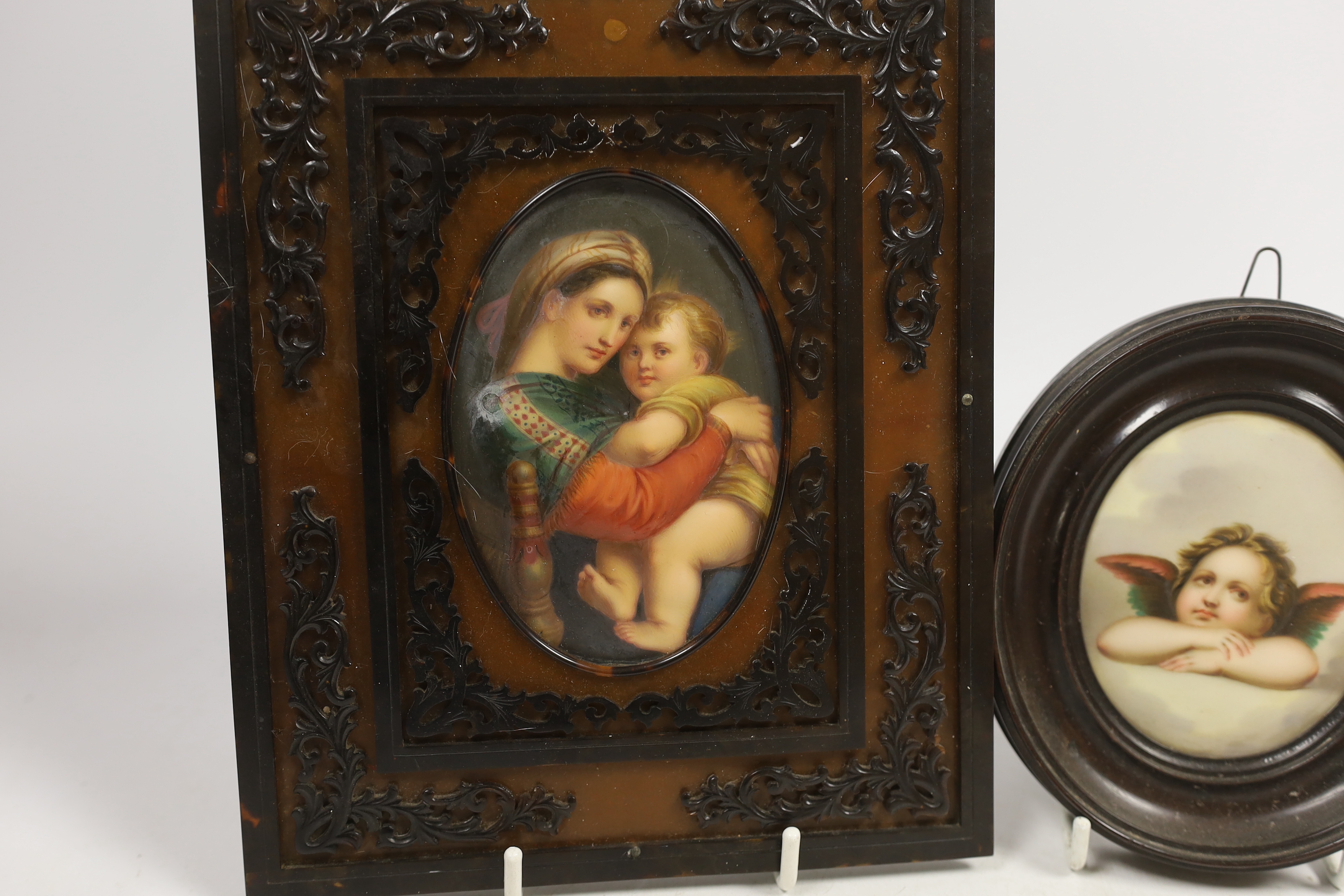 An oval porcelain plaque of mother and child in an ornate frame and a smaller circular porcelain plaque of a putti, mother and child plaque 10.5cm high